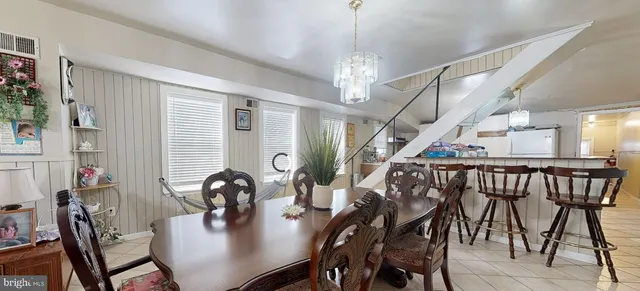 a kitchen with stainless steel appliances granite countertop a sink dishwasher a stove a dining table and chairs with wooden floor