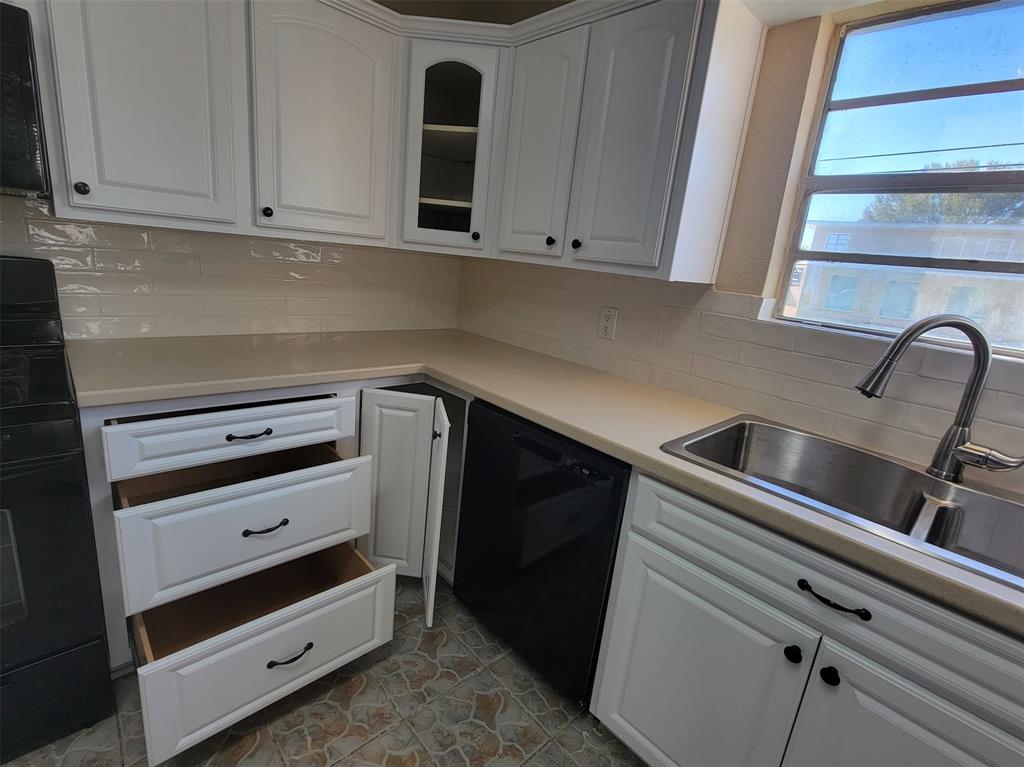 a kitchen with granite countertop white cabinets and a stove