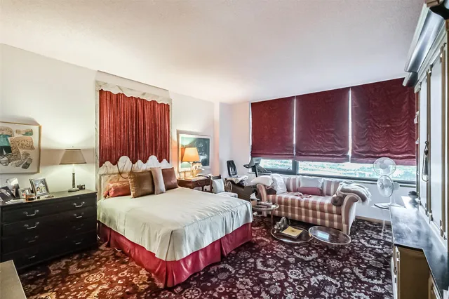 a bedroom with a bed and large windows