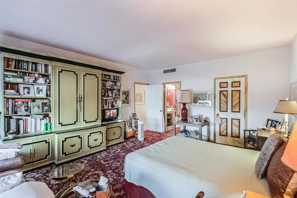 a bedroom with a bed and large windows