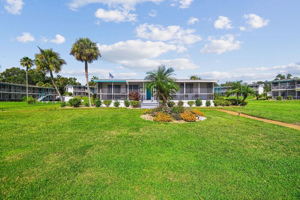 1600 West Lake Parker Drive, Unit B22 Lakeland, FL 33805 - Photo 19 of 26 a view of a house with a big yard and potted plants