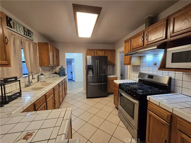 a kitchen with stainless steel appliances granite countertop a stove a sink and a refrigerator