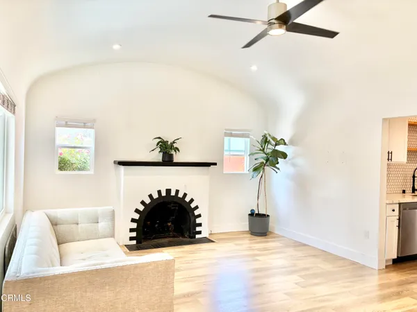a living room with furniture and a dining table with kitchen view