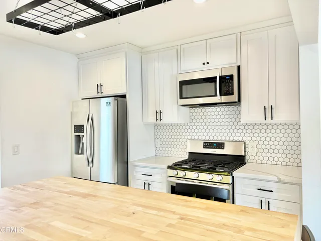 a kitchen with stainless steel appliances a stove a microwave and a refrigerator