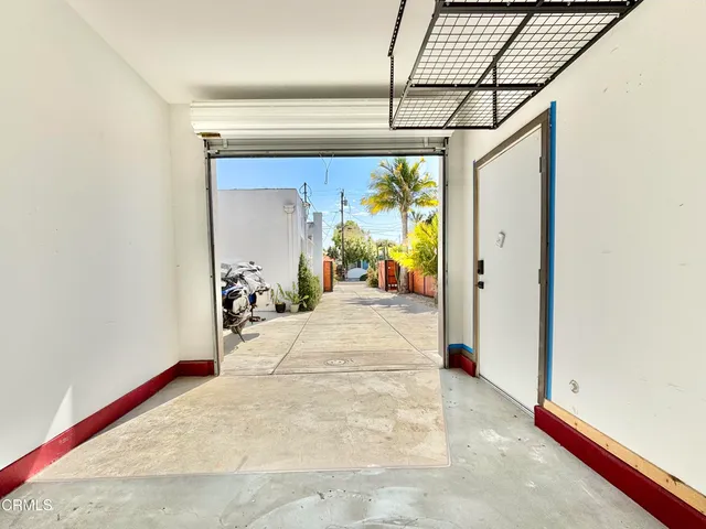 a view of a white house with potted plants