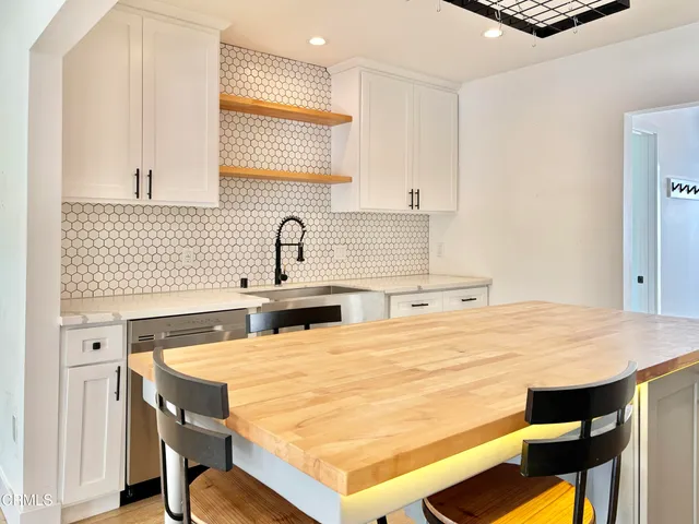 a kitchen with a table chairs sink and cabinets