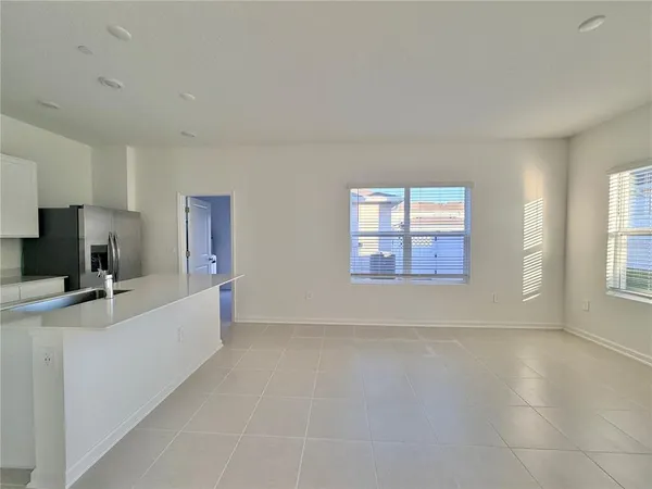 a view of a kitchen with a sink and dishwasher a refrigerator with white cabinets