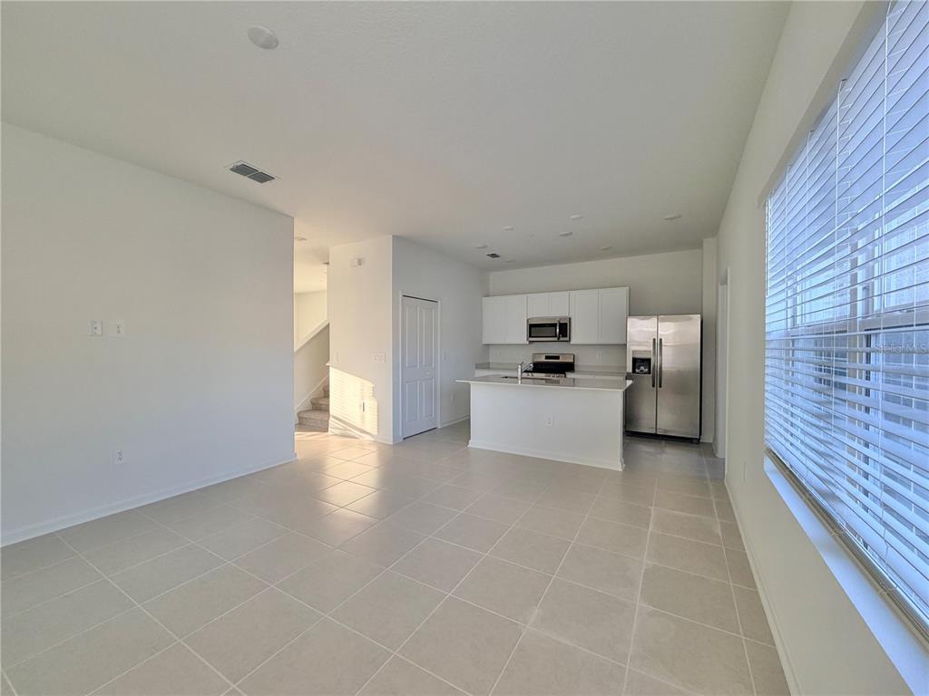 2348 Rider Rain Lane Apopka, FL 32703 - Photo 9 of 32 a view of a kitchen with a sink and dishwasher a refrigerator with white cabinets