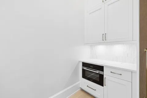 an empty room with wooden floor and ceiling fan