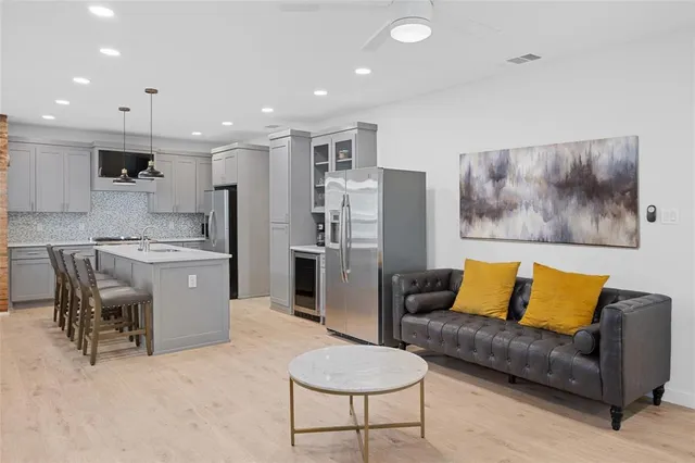a living room with furniture and a dining table with kitchen view
