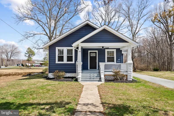 a front view of a house with a yard covered in snow