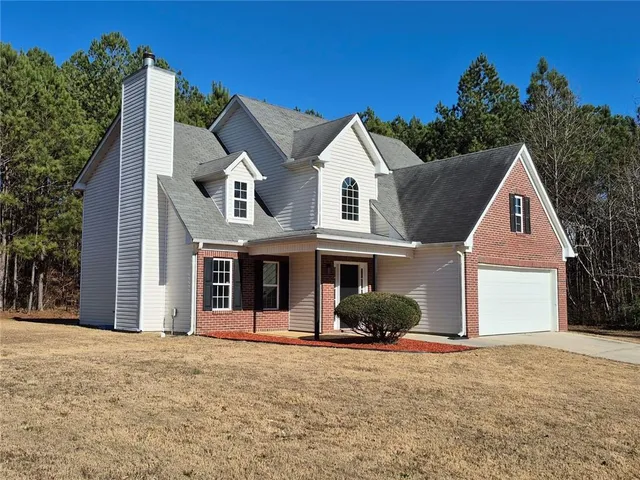 a view of a white house with a yard and large tree