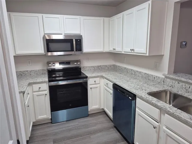 a kitchen with white cabinets and stainless steel appliances