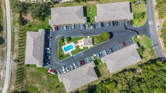 aerial view of a chairs and table in front of a house
