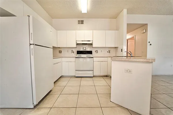 a kitchen with white cabinets a sink and white appliances