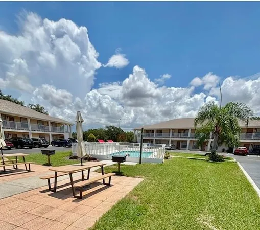 a swimming pool with outdoor seating and a garden