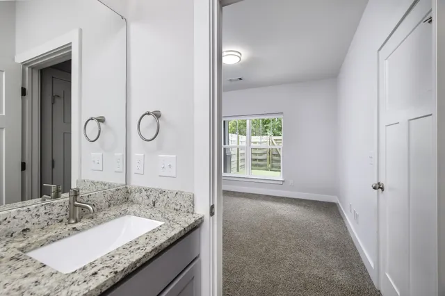 a bathroom with a granite countertop sink and a mirror