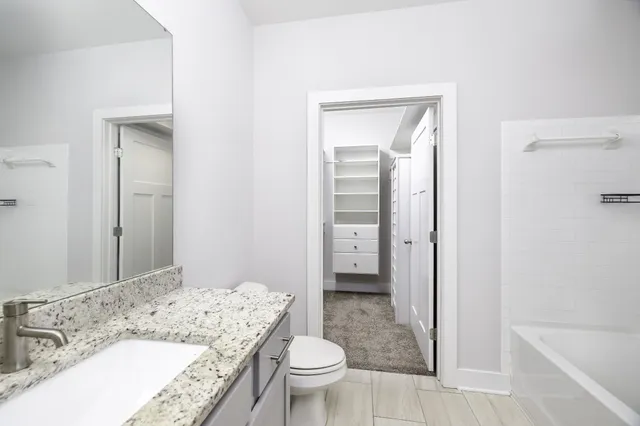 a bathroom with a granite countertop sink toilet and shower