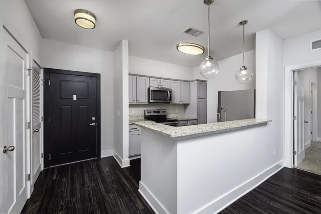 a kitchen with stainless steel appliances a stove a refrigerator and a microwave