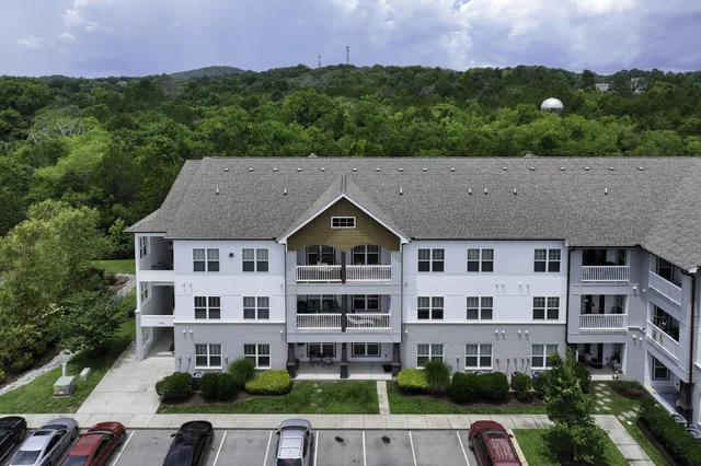 a aerial view of a house next to a big yard and large trees