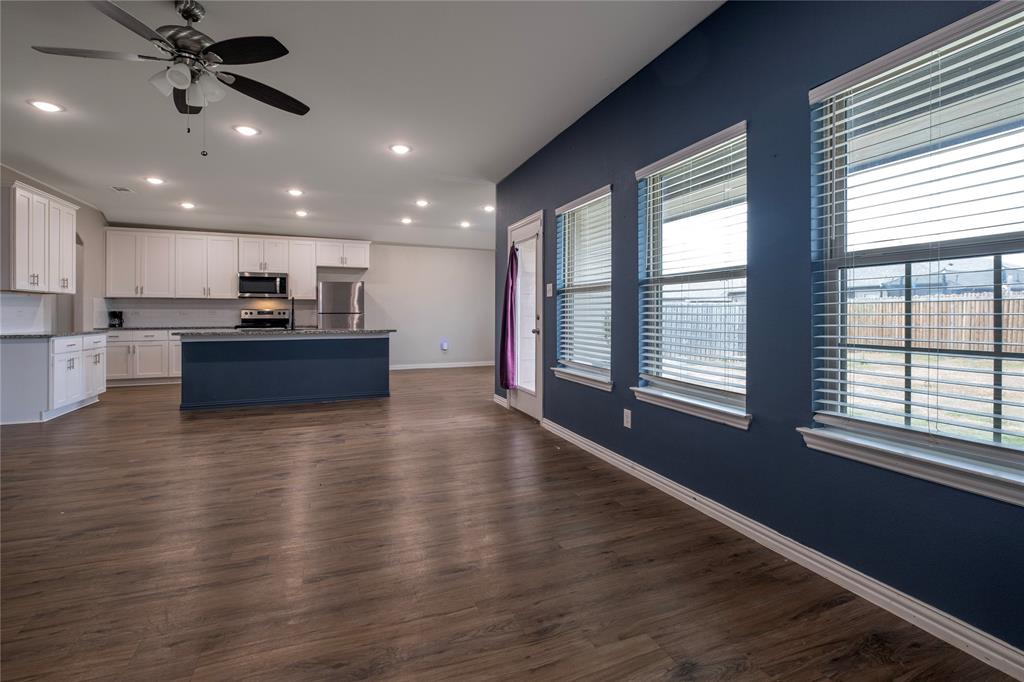 106 Spring Crest Street Mabank, TX 75147 - Photo 4 of 22 a view of a kitchen with kitchen island a sink wooden floor and a large window
