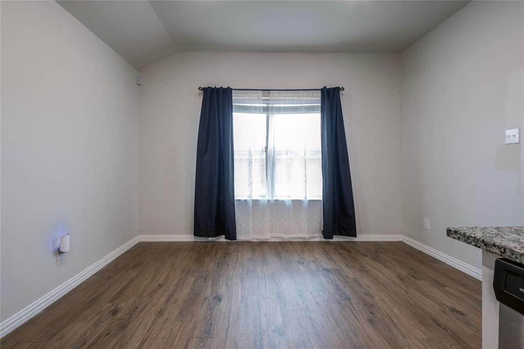 106 Spring Crest Street Mabank, TX 75147 - Photo 6 of 22 a view of an empty room with wooden floor and a window