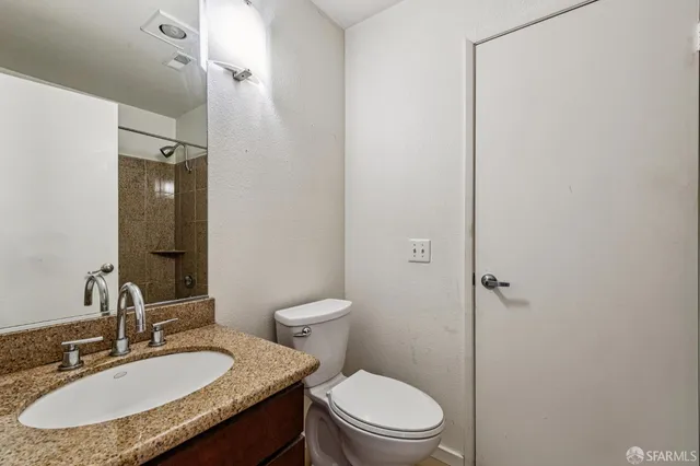 a bathroom with a granite countertop sink toilet and shower