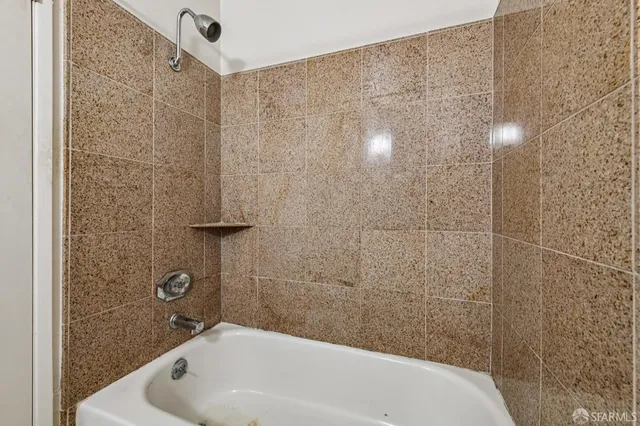 a bathroom with a white bath tub and shower