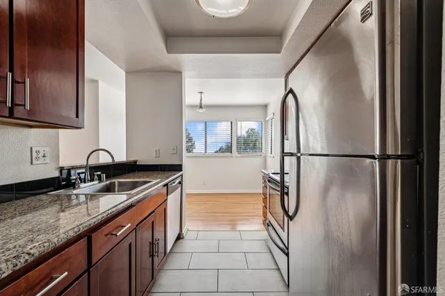 a kitchen with stainless steel appliances granite countertop a sink and a refrigerator