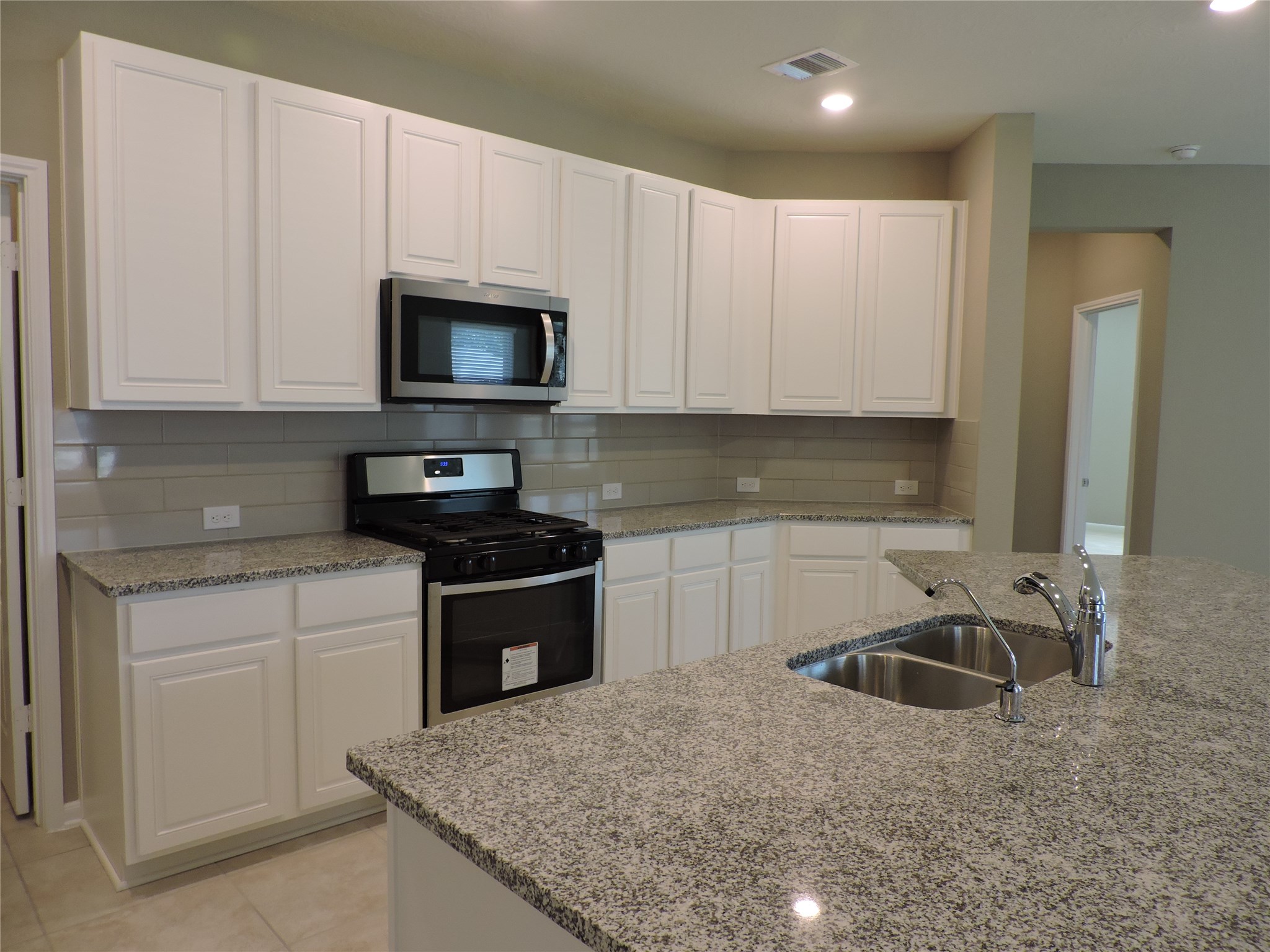 1102 Upton Court Conroe, TX 77304 - Photo 7 of 30 a kitchen with granite countertop a sink a stove and cabinets