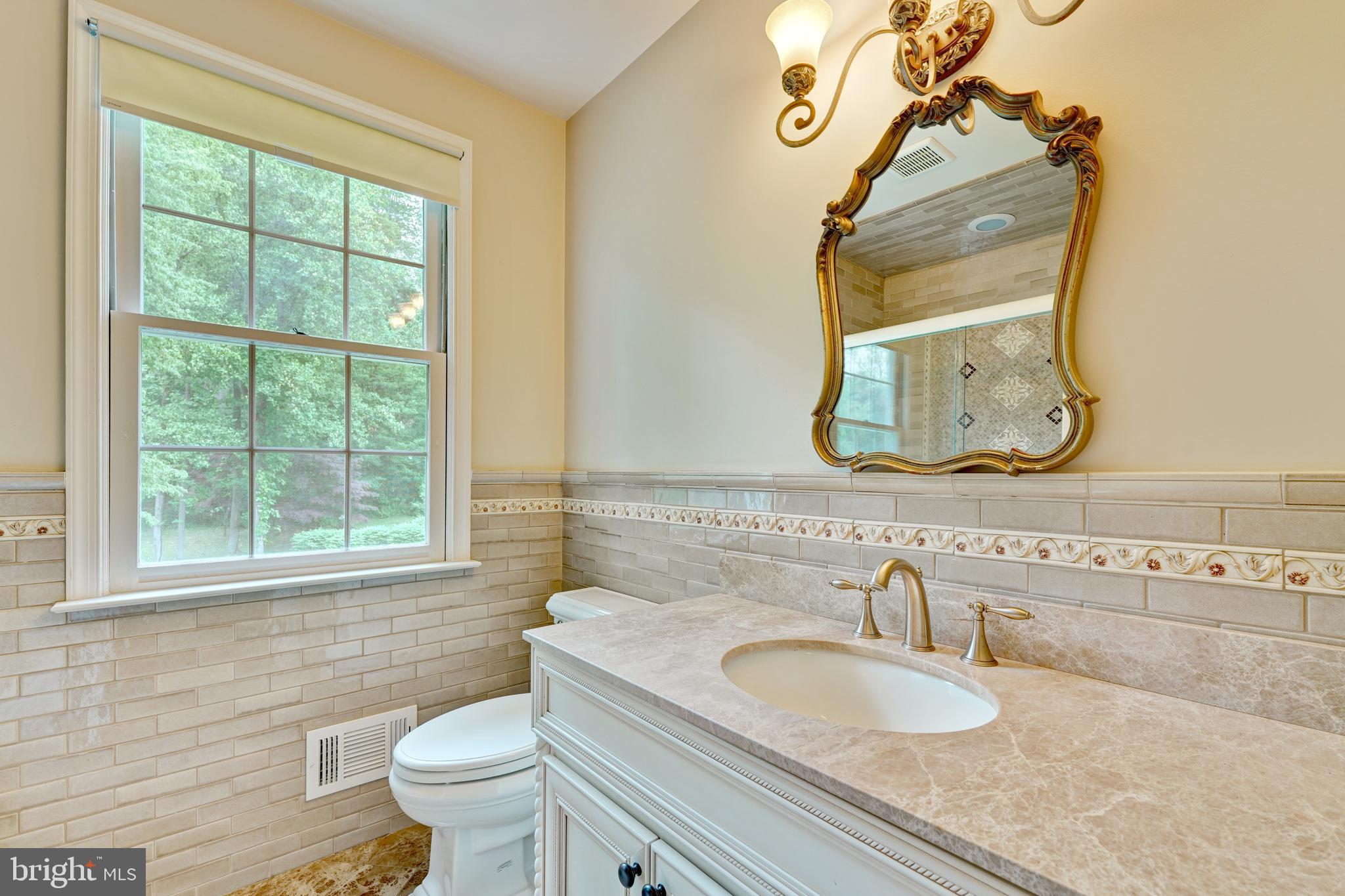 741 Campwoods Road Villanova, PA 19085 - Photo 26 of 48 a bathroom with a granite countertop toilet a sink and a mirror