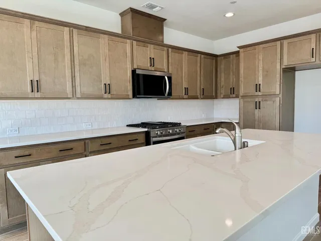 a kitchen with stainless steel appliances a sink and a refrigerator