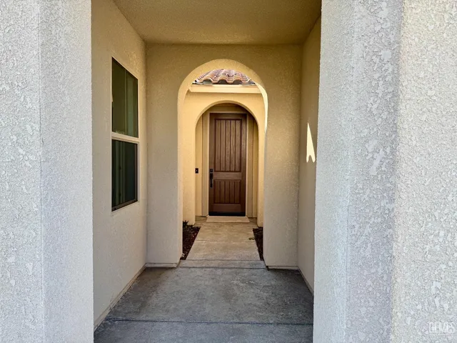 a view of a hallway with entryway a flat screen tv and a fireplace
