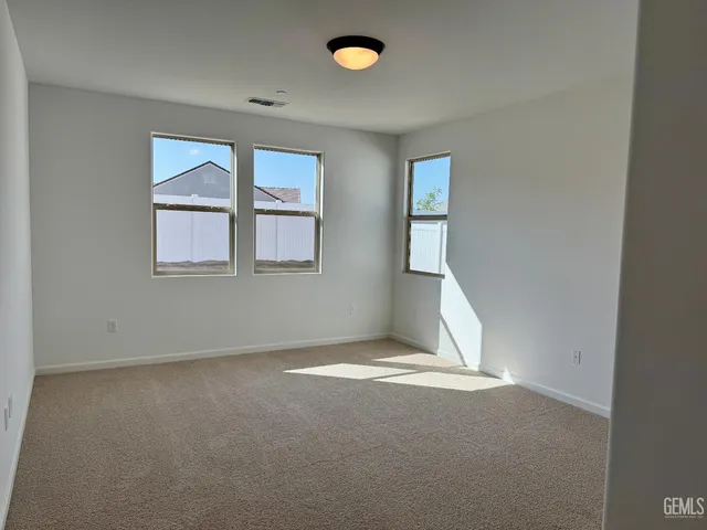 a view of a room with wooden floor and a ceiling fan