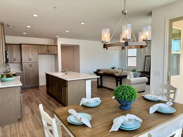 a kitchen with stainless steel appliances kitchen island granite countertop table and chairs