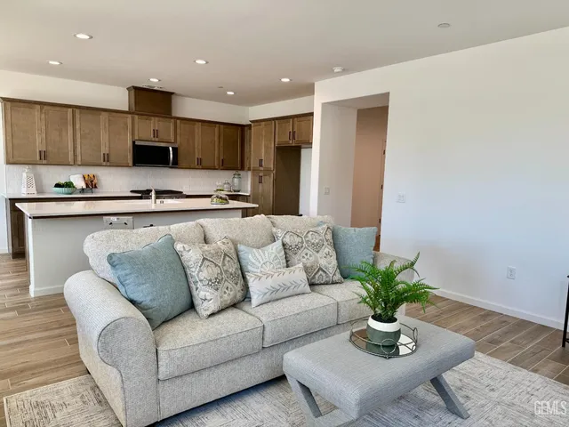 a living room with furniture kitchen view and a potted plant