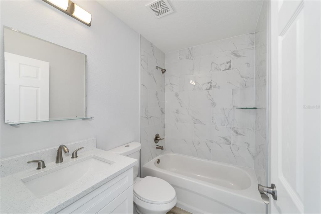 3467 Southwest 150th Court Ocala, FL 34481 - Photo 28 of 35 a bathroom with a bathtub shower sink mirror vanity and toilet