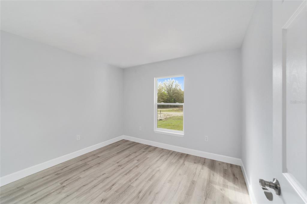 3467 Southwest 150th Court Ocala, FL 34481 - Photo 29 of 35 a view of an empty room with a window and wooden floor