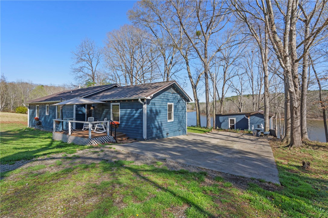 122 Latham Drive Anderson, SC 29621 - Photo 39 of 40 A charming lakefront home with a welcoming deck and ample parking, set amidst mature trees.