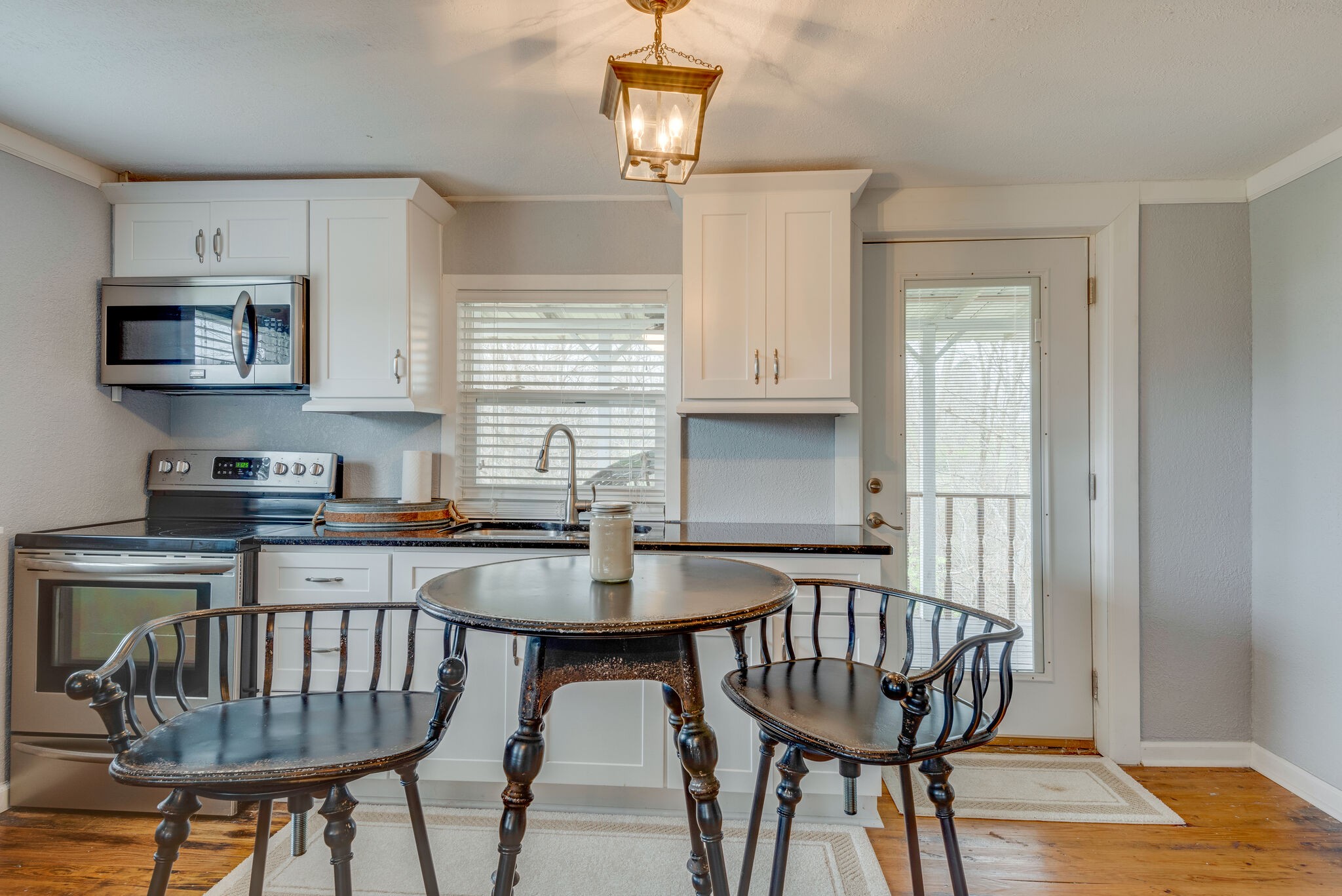 7606 Pewitt Road Franklin, TN 37064 - Photo 11 of 28 a kitchen with stainless steel appliances granite countertop a dining table chairs refrigerator and microwave