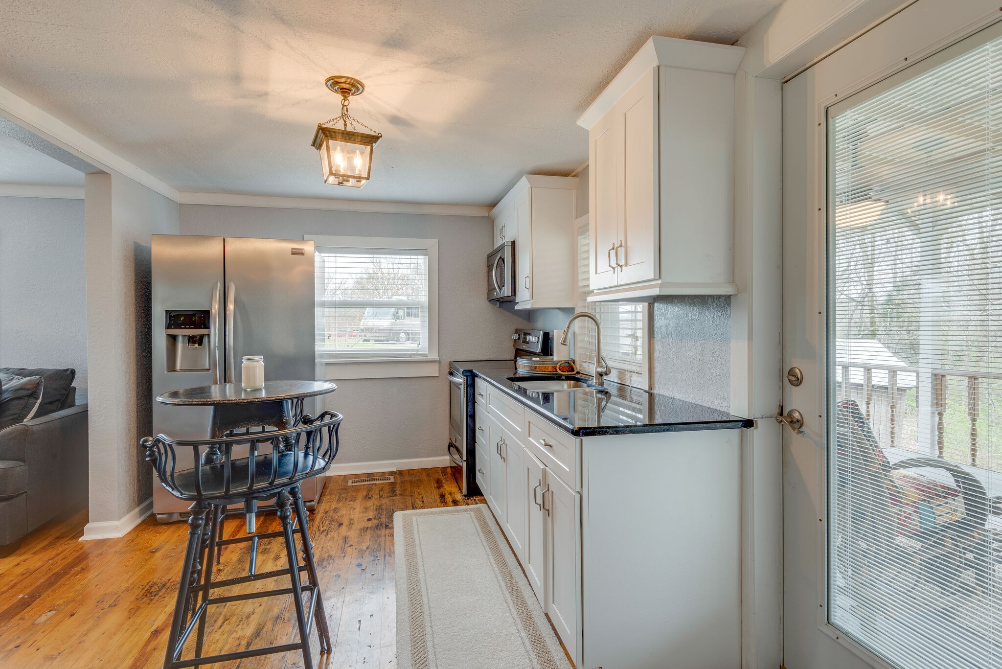 7606 Pewitt Road Franklin, TN 37064 - Photo 14 of 28 a kitchen with stainless steel appliances granite countertop a stove top oven a sink a dining table and chairs with wooden floor