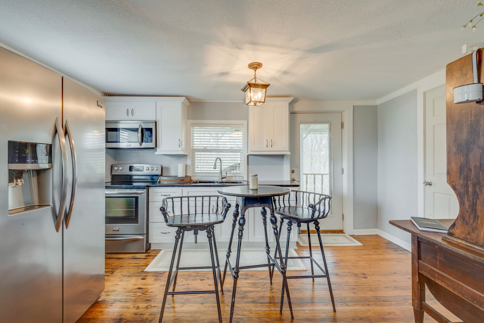 7606 Pewitt Road Franklin, TN 37064 - Photo 10 of 28 a kitchen with stainless steel appliances granite countertop a dining table chairs refrigerator and microwave
