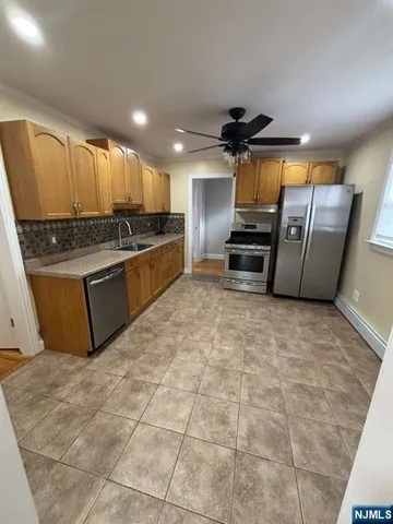 a kitchen with stainless steel appliances granite countertop a stove a sink and a refrigerator