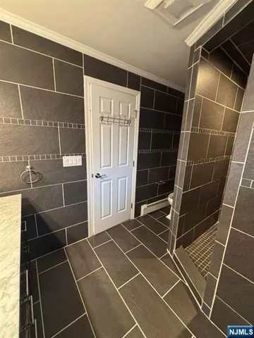 a bathroom with a glass door shower and a shower