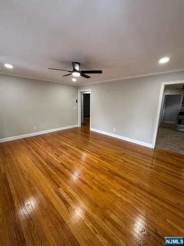 a view of an empty room with wooden floor