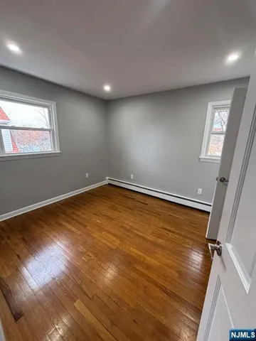a view of room with window and wooden floor