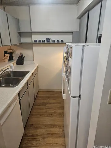 a view of a kitchen with sink and refrigerator