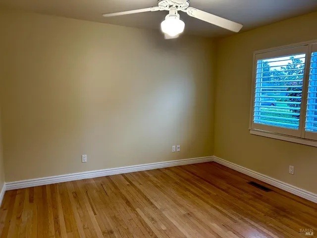 a view of a room with wooden floor and fan