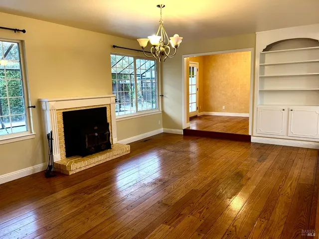a living room with hard wood floors and a fireplace
