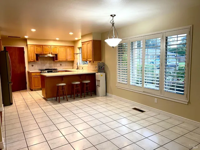 a kitchen with stainless steel appliances granite countertop a stove a sink and a refrigerator